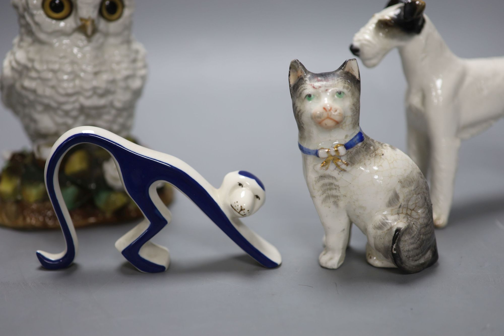 A Victorian porcelain owl oil lamp base, lacking mount, an Austrian porcelain terrier and two other ceramic animals, tallest 16.5cm